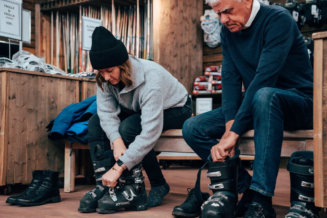 Två sitter och provar pjäxor inne på Kläppens skiduthyrning