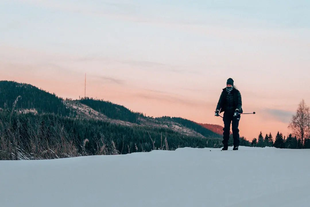 A cross-country skier skis on Älvspåret at sunrise.