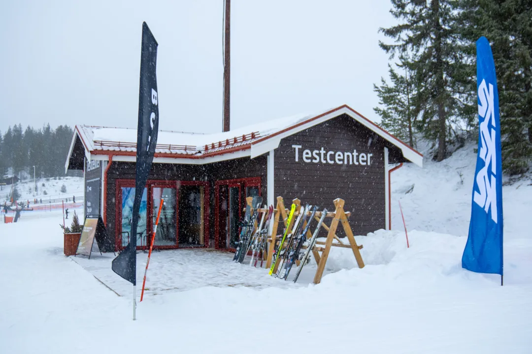 Test centre where the ski racks are filled with various models of skis and snowboards