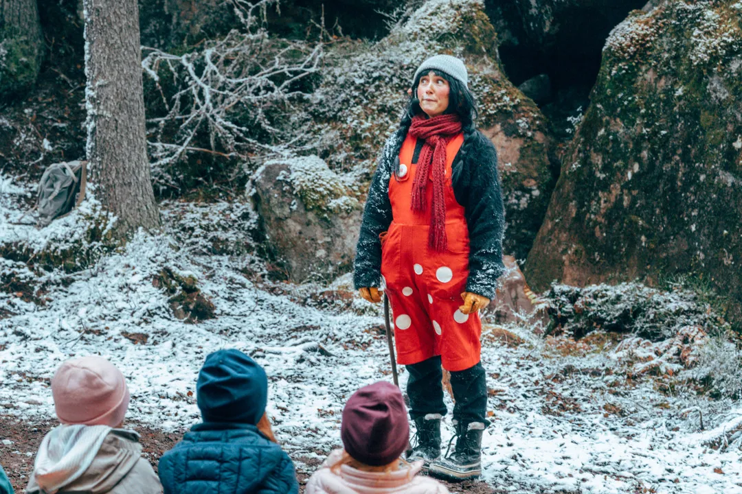 The troll Trolla performs in the forest in front of several children.