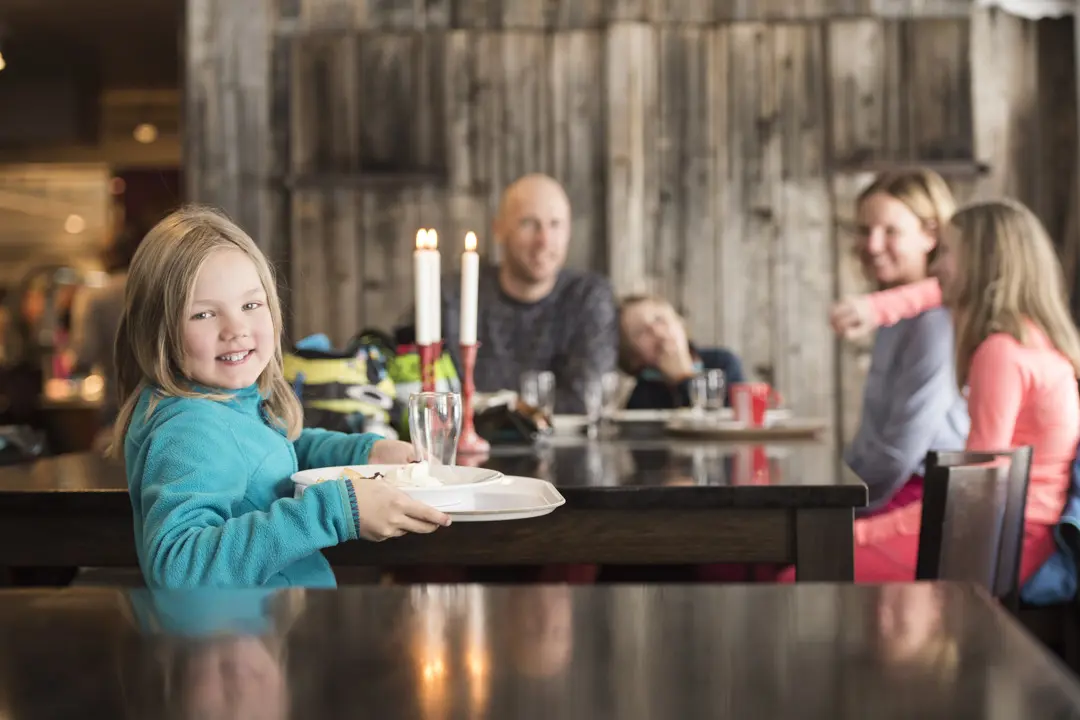 A family with children enjoys a tray lunch at Tranan.