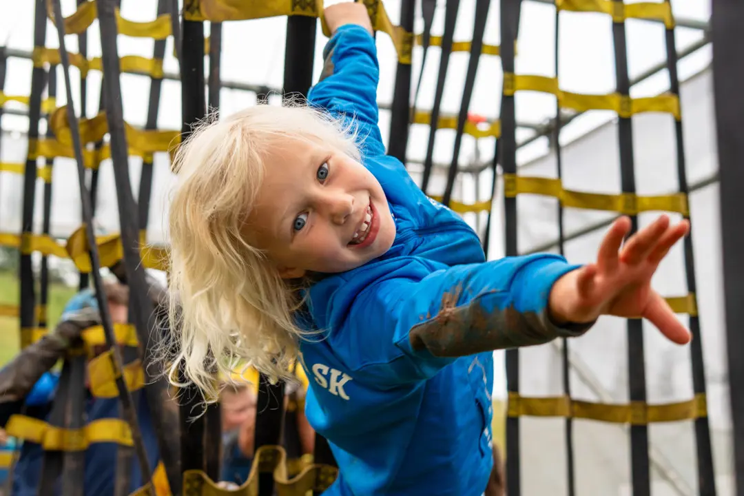 A child running the Toyghest race and getting through by climbing