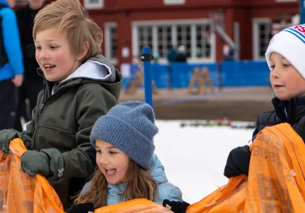 Three happy children are playing sack race at Tranantorget.