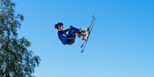 A guy performing tricks with skis in the air at Kläppen Arena
