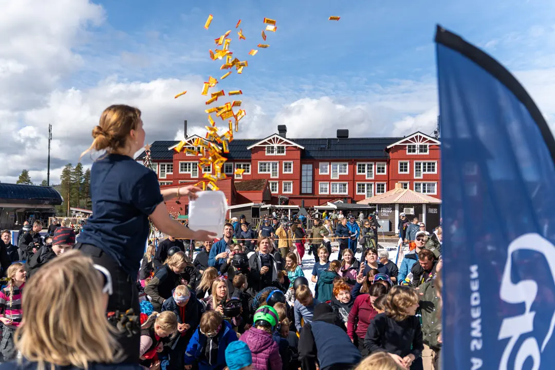 En flicka kastar ut Kexchoklad till barn som samlats på Tranantorget
