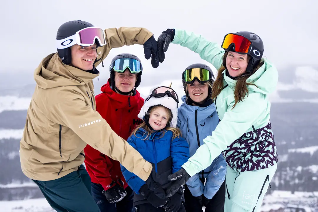The entire Eriksson family is on the slope, smiling at the camera.