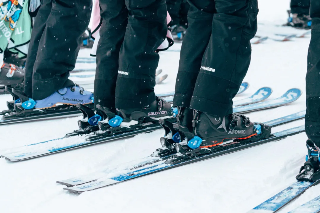 Ett par skidåkare står i backen med skidorna på